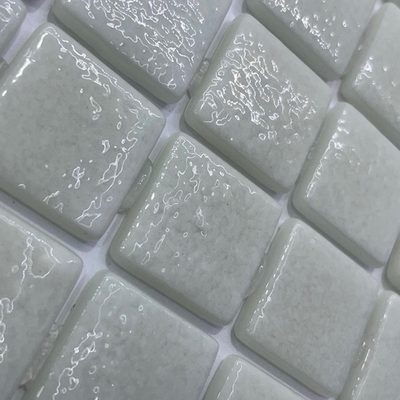 Pâte de verre en carrés 2,5 cm, blanche, mouchetée. Pour piscines, hammams et douches.